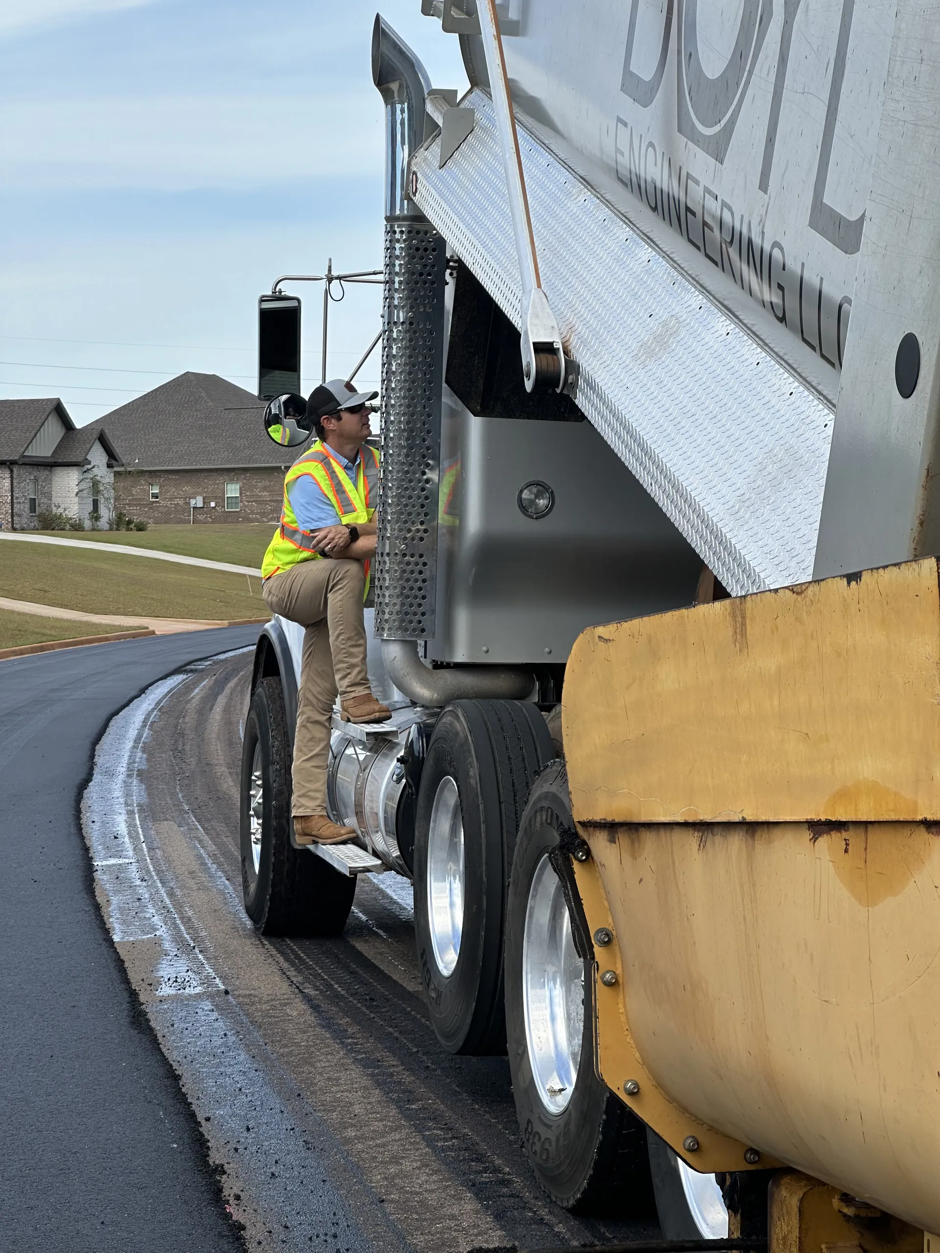 Project One Contracting owner on a dump truck at a fresh-paved North Alabama street